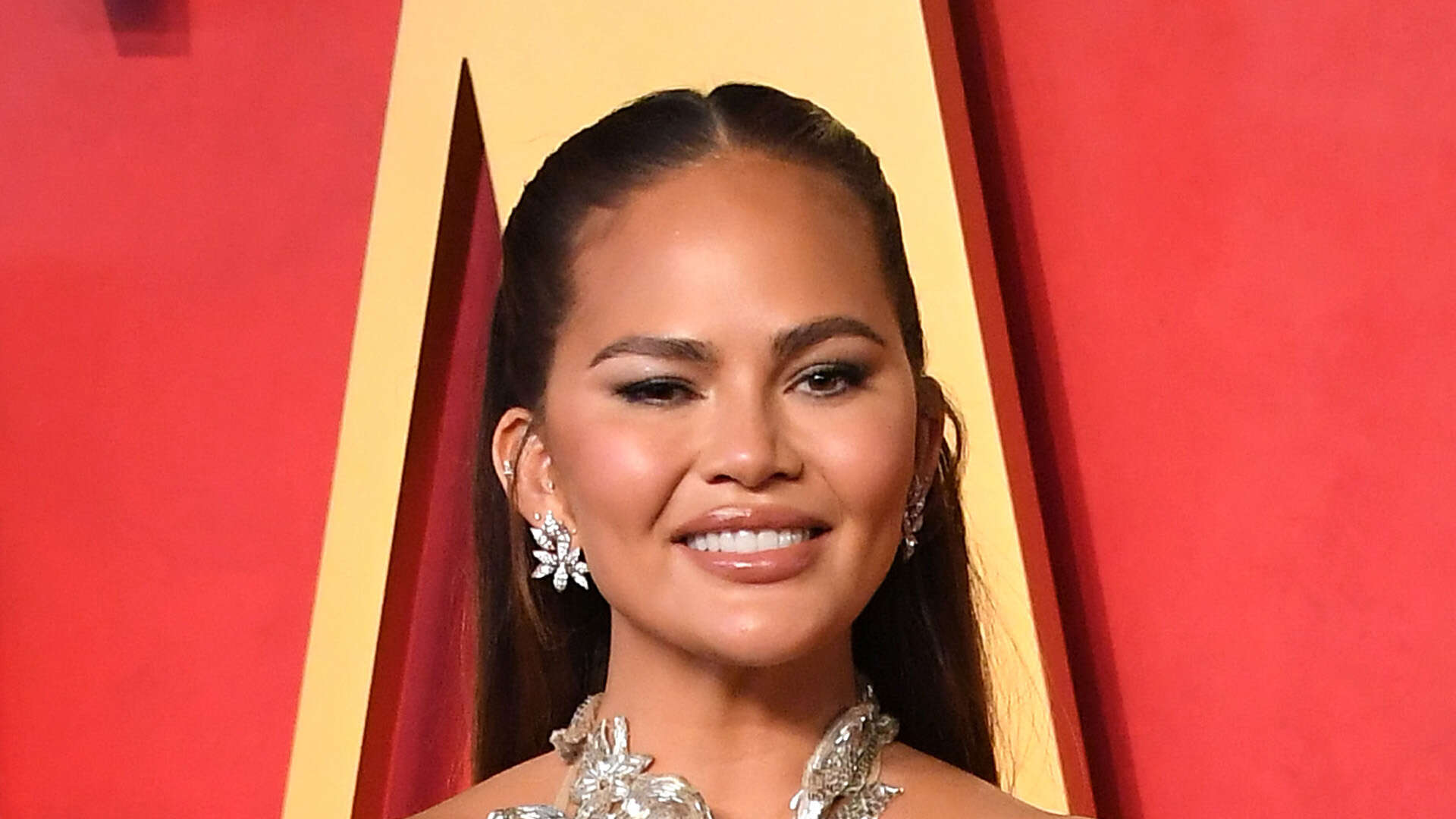 Chrissy Teigen reveals ‘boob lift scars’ as she poses in see-through dress and says she can tell fans are ‘zooming in’