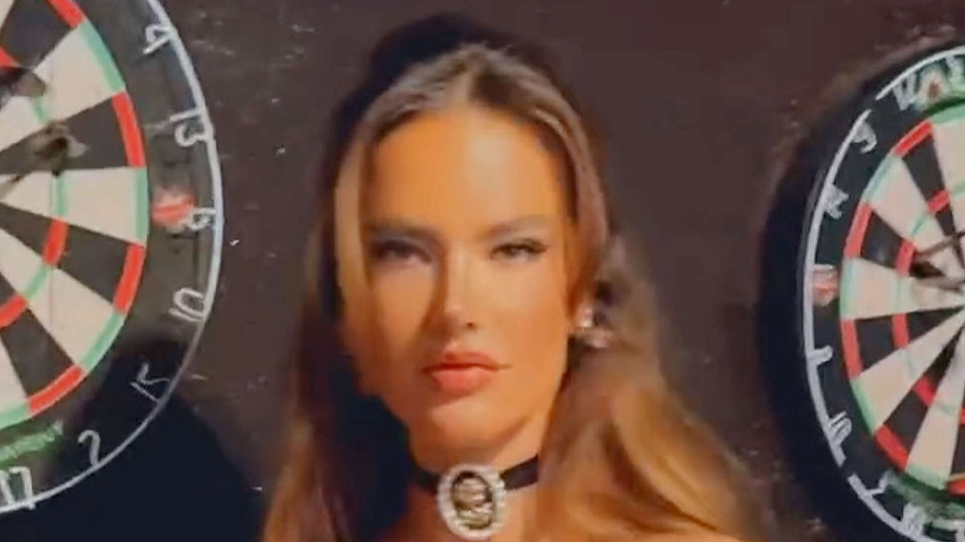 Alessandra Ambrosio rocks just a leather corset and fishnets as she plays darts in Colorado