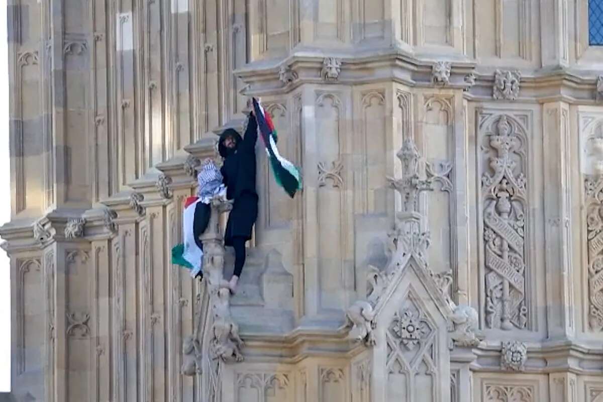 Un hombre trepa la torre del Big Ben con una bandera de Palestina