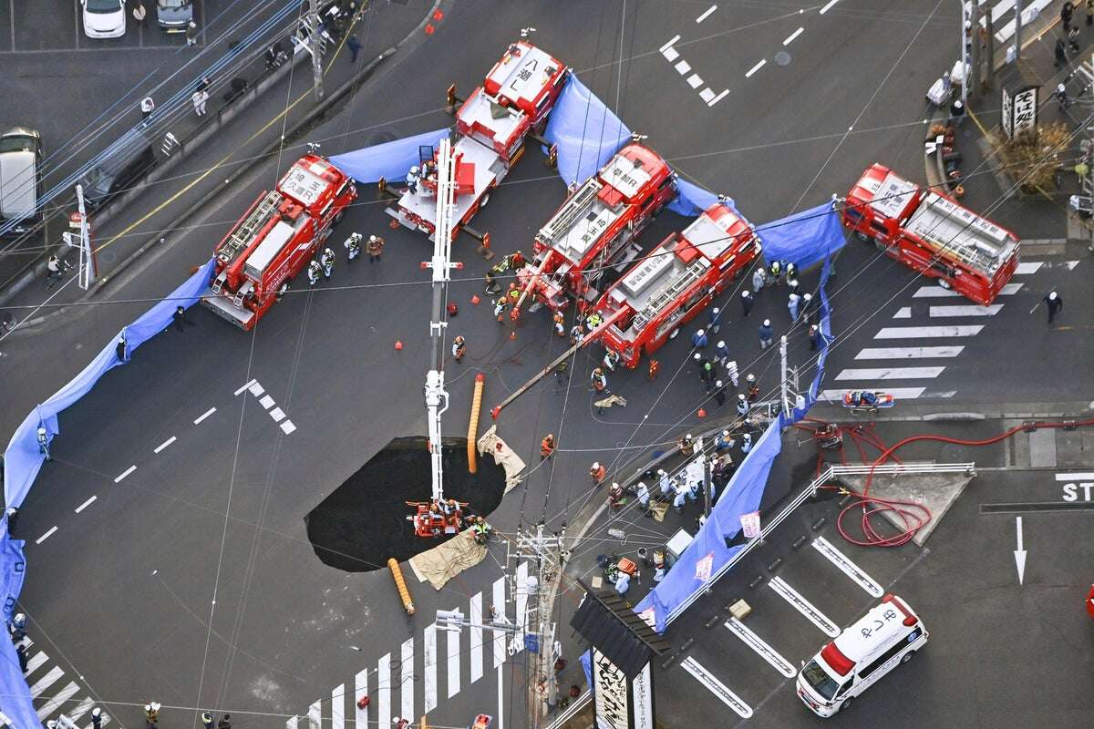 Families near Japan sinkhole asked to leave as driver remains trapped