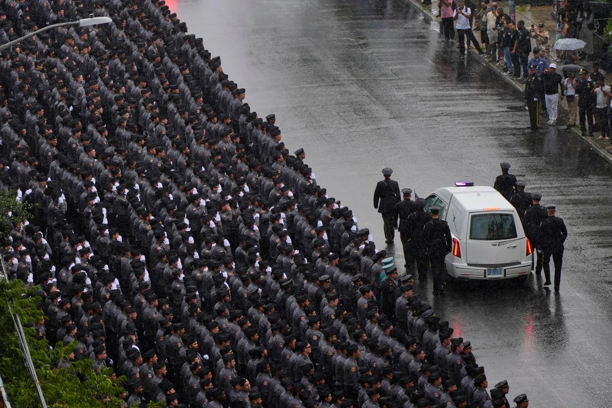 Thousands gather to farewell NYPD officer killed in mass shooting