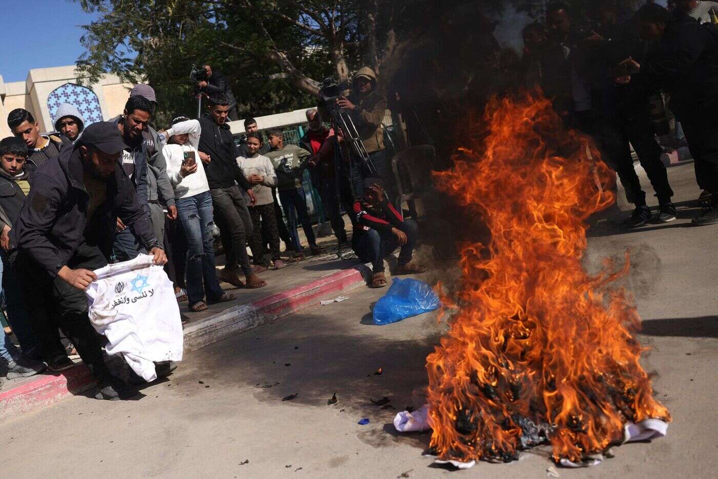 Gaza : à Khan Younès, des Palestiniens libérés mettent le feu aux sweat-shirts imposés par Israël