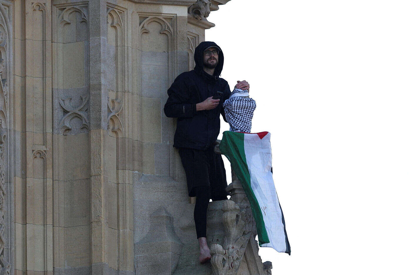 Un homme escalade Big Ben avec un drapeau palestinien à Londres