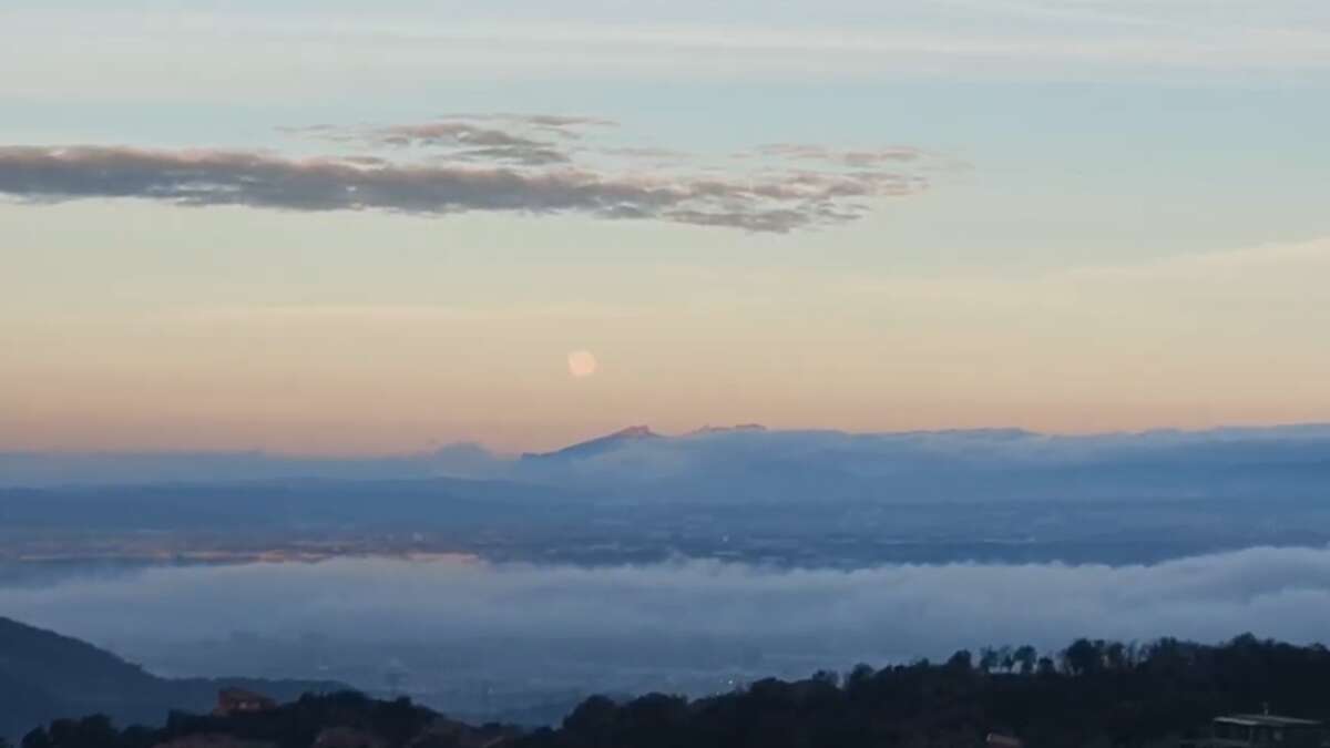 Mira la luna llena de nieve sobre Montserrat