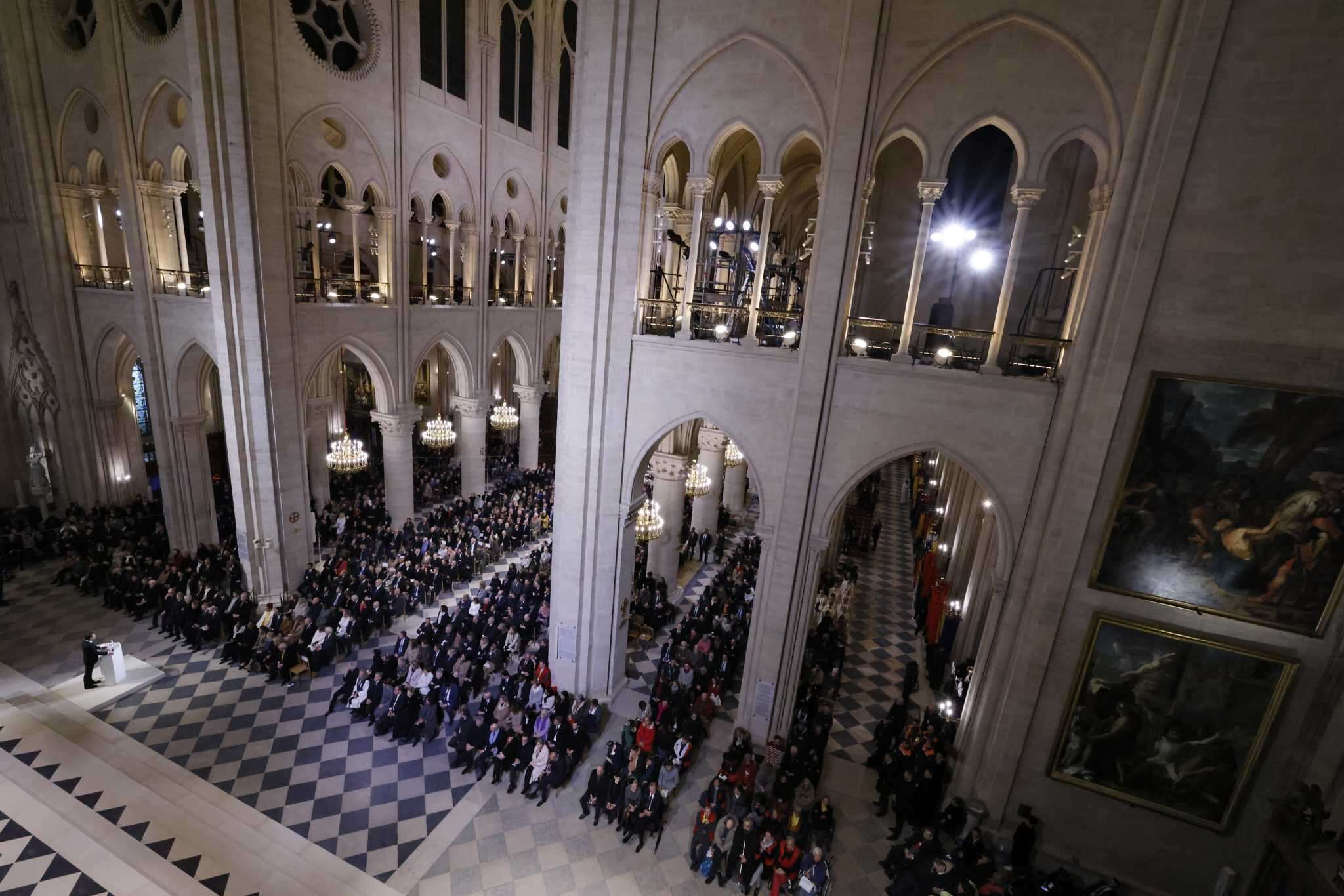 An archbishop's knock formally restores Notre Dame to life as winds howl and heads of state look on