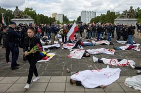 Des manifestants simulent la mort devant le mémorial soviétique à Varsovie