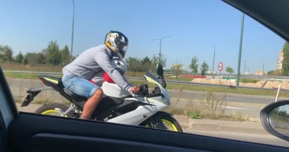 Pędził ruchliwa ulica na motocyklu. Z przodu siedziało małe dziecko