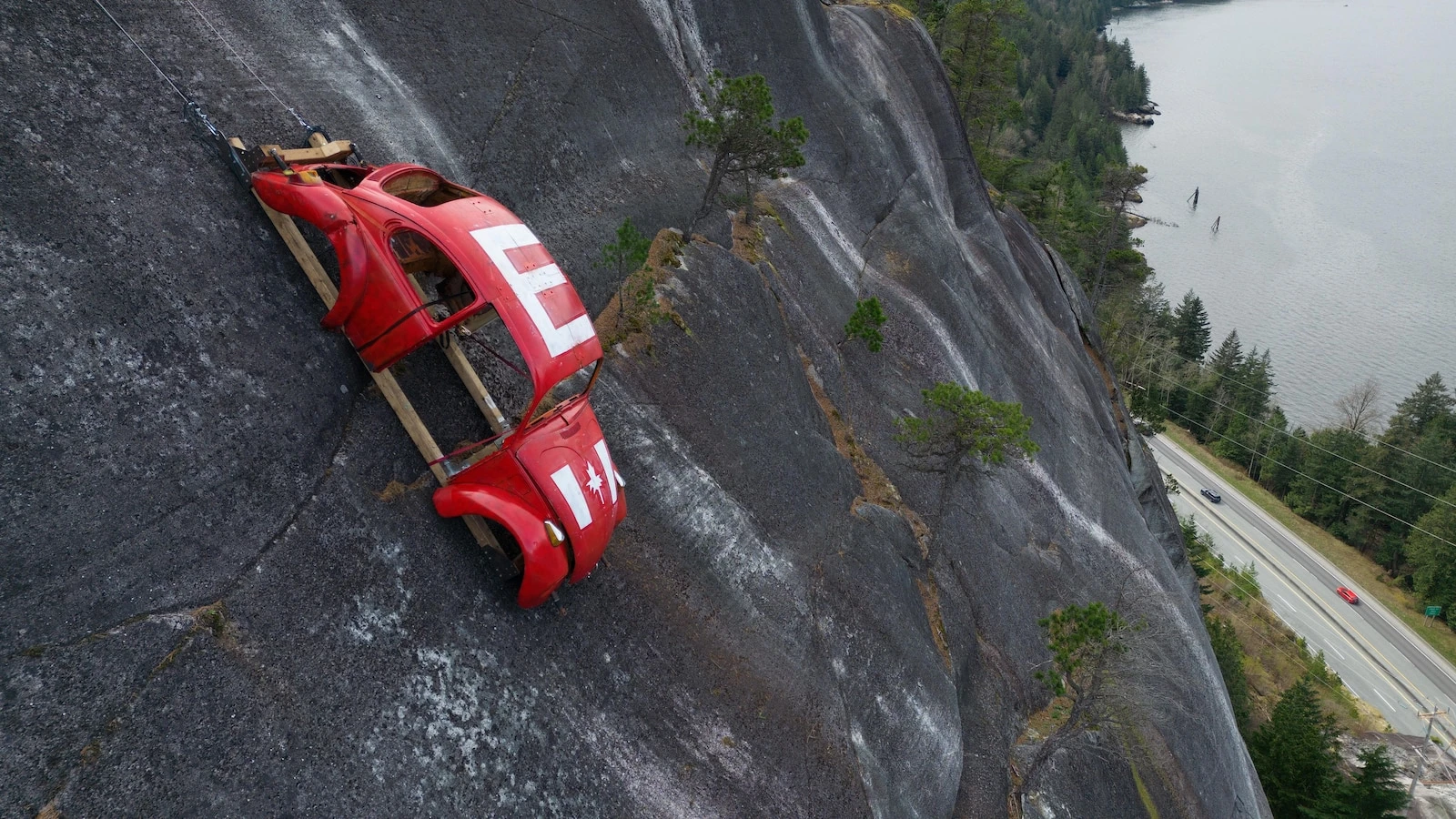 Car shell suspended on rock face above British Columbia highway in apparent prank