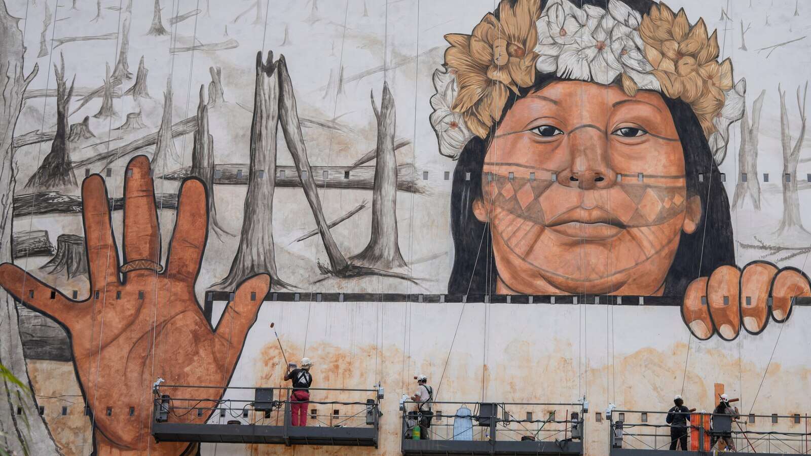 A Brazilian artist uses ash and mud for a massive Sao Paulo mural lamenting climate disasters