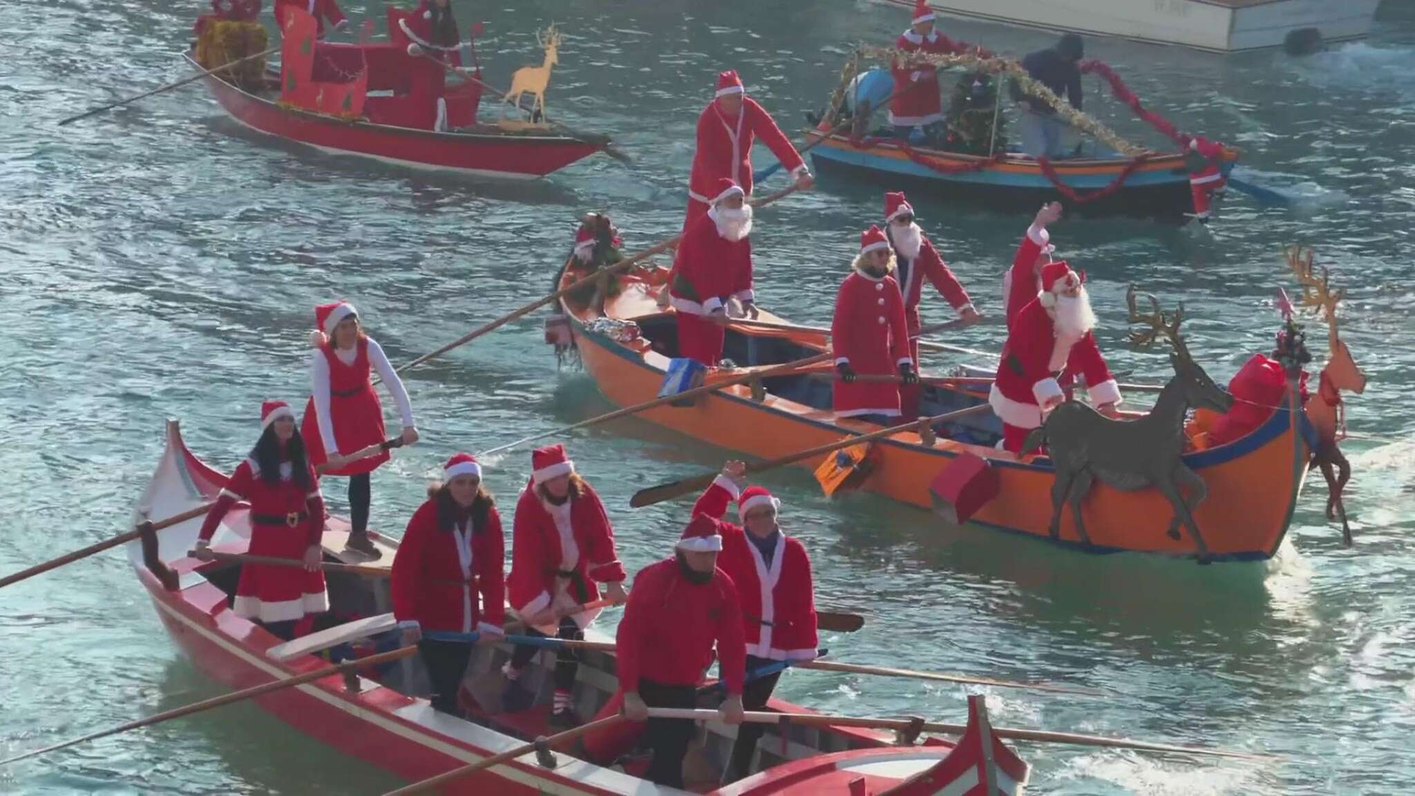 Venezia, le immagini del corteo acqueo dei Babbi Natale a remi sul Canal Grande