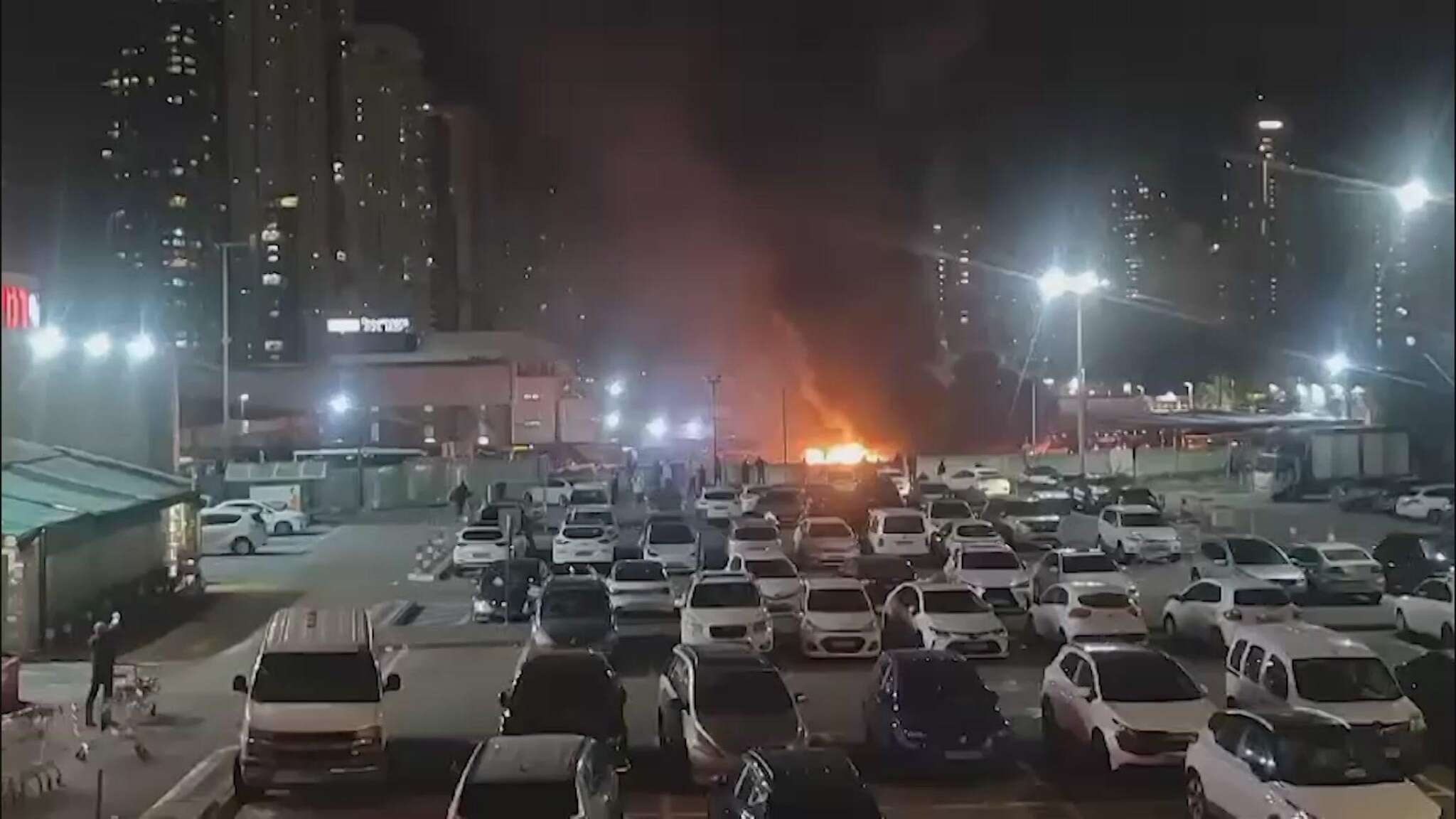 Tel Aviv, le fiamme avvolgono la carcassa di uno degli autobus esplosi e il fumo arriva al cielo