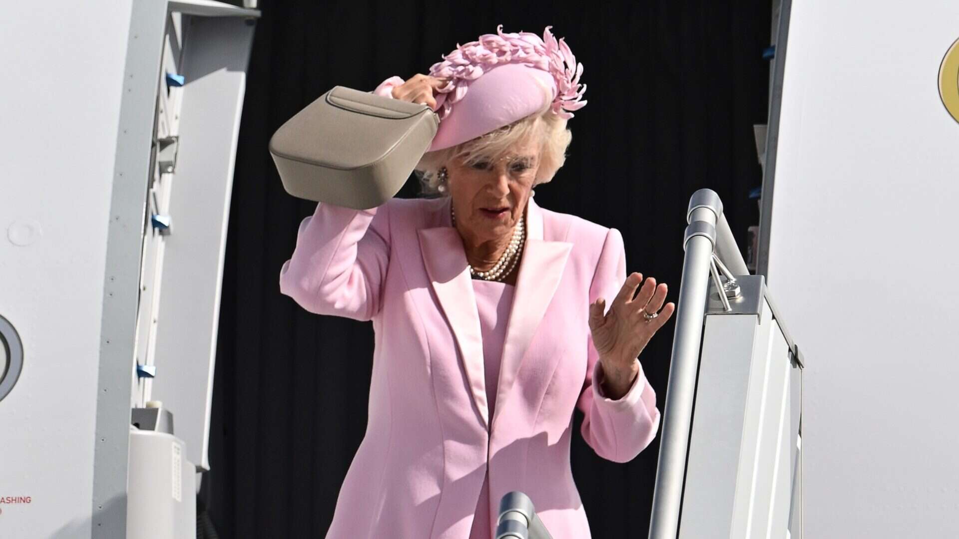 La regina Camilla arriva a Parigi in total pink (ma rischia di perdere il cappellino)