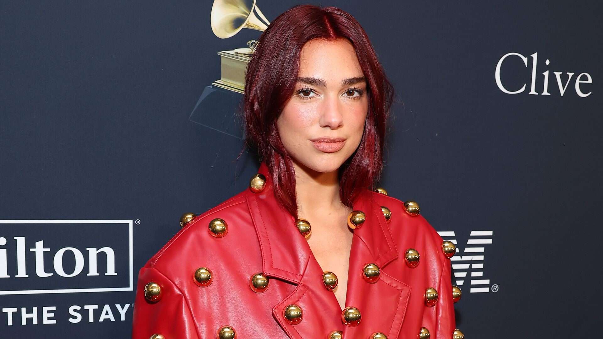 Dua Lipa al Pre Grammy Gala 2024 con un trench in pelle tempestato di bottoni