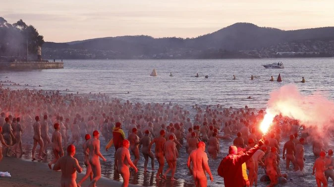 Wild scenes as hundreds run naked to water