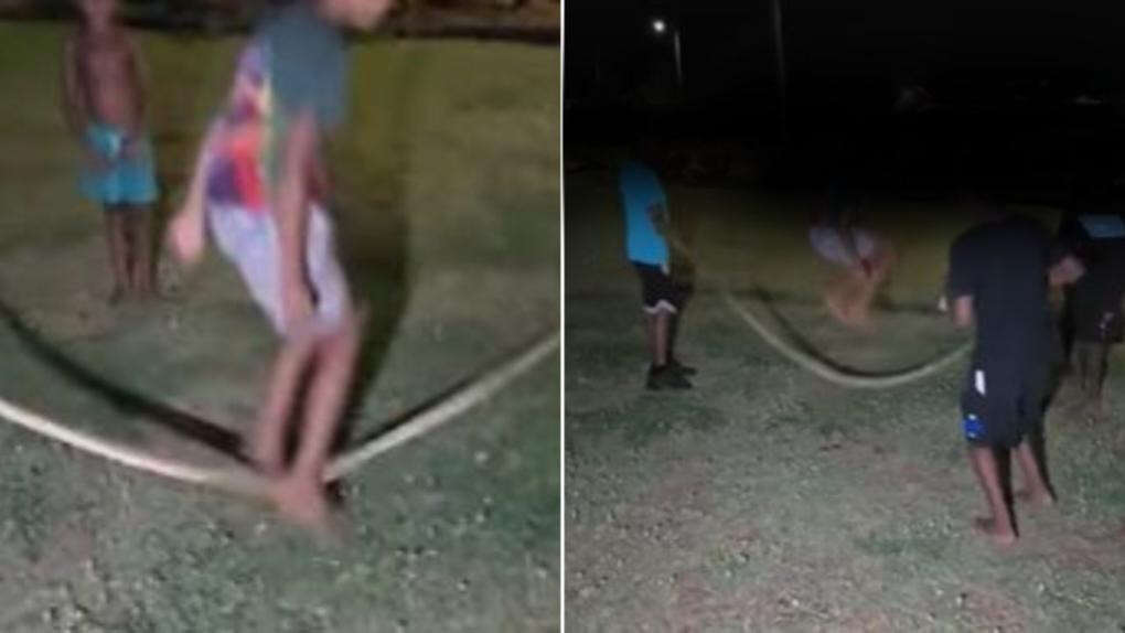 Dead python used as a skipping rope by children