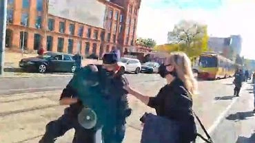 d. Policjant nagle przewrci na ziemi demonstranta. Nagranie obiego sie
