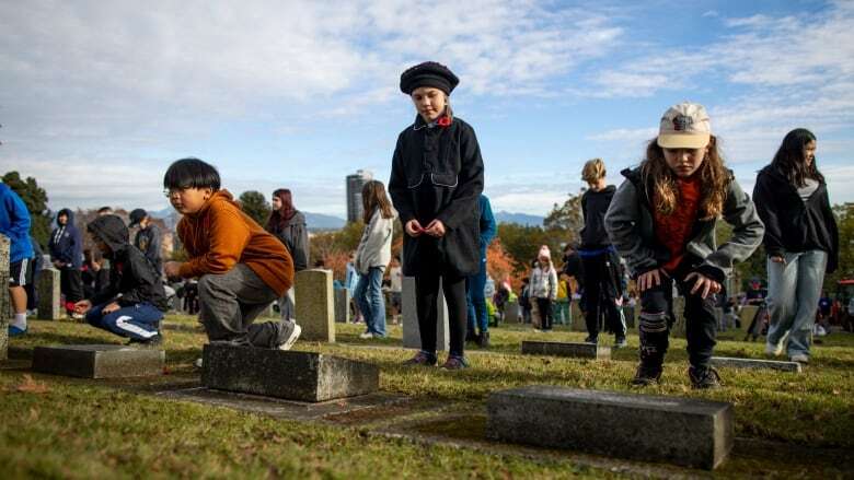 Children lay poppies on veterans' headstones in B.C. as part of No Stone Left Alone initiative