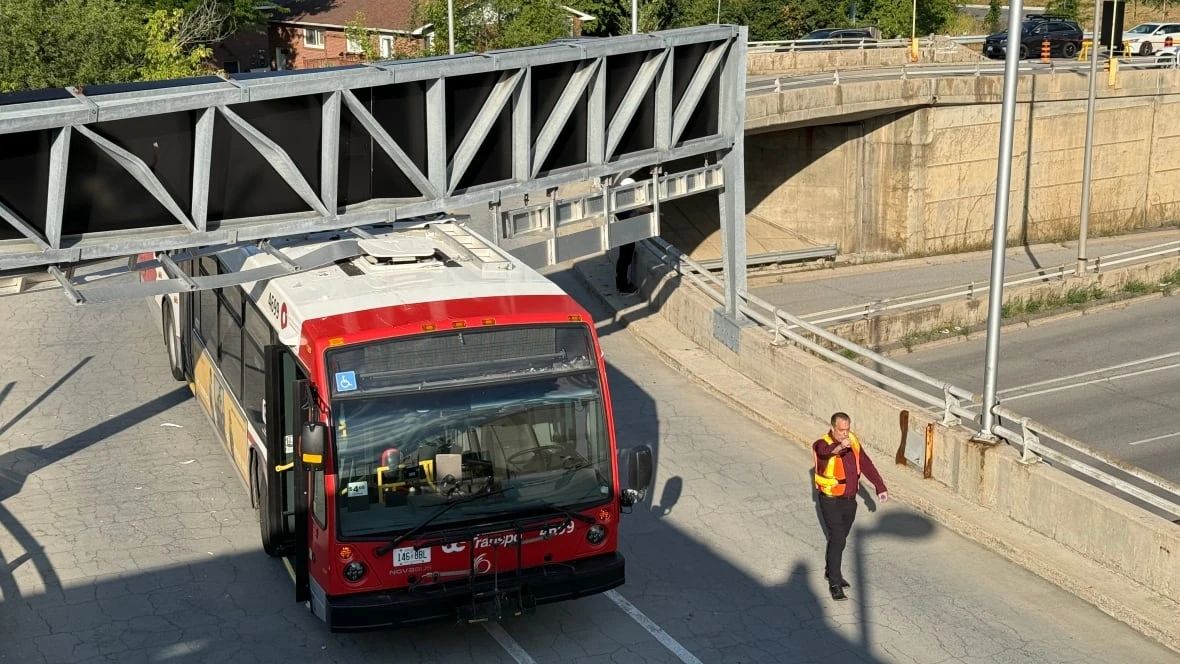Out-of-service OC Transpo bus gets stuck under shopping mall sign