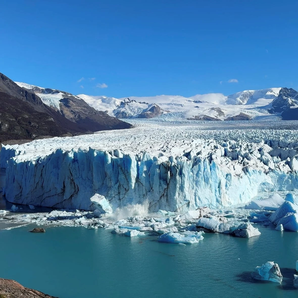 Tourists watch as a massive chunk of ice breaks off Argentinian glacier