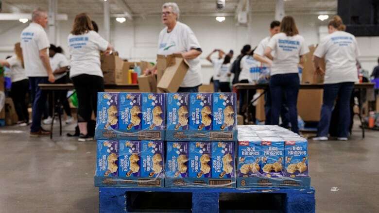 Volunteers pack healthy food for kids in need this summer