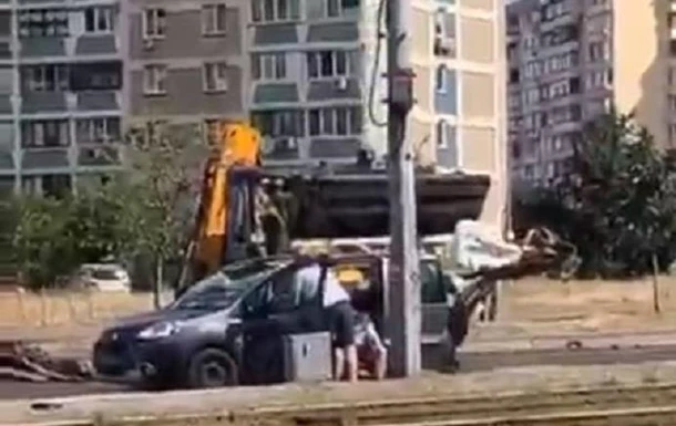 У Києві екскаватор вдарив ковшем по даху авто