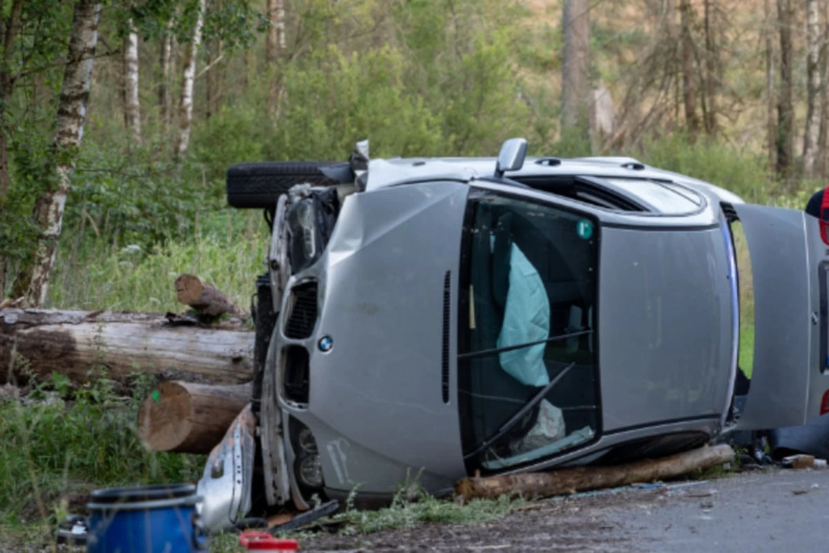 Zu schnell unterwegs? BMW kracht gegen Holzstoß und kippt um