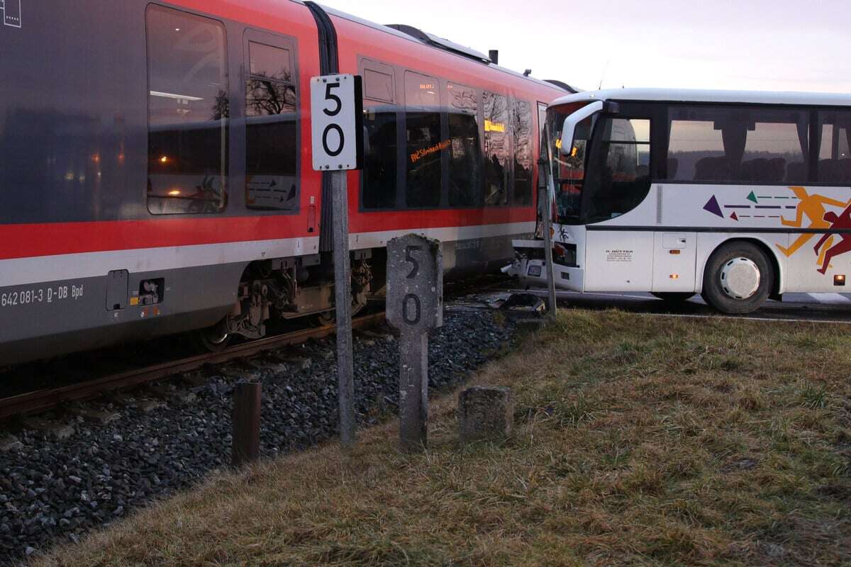 Drama an Problem-Bahnübergang: Bus fährt in vorbeifahrenden Zug