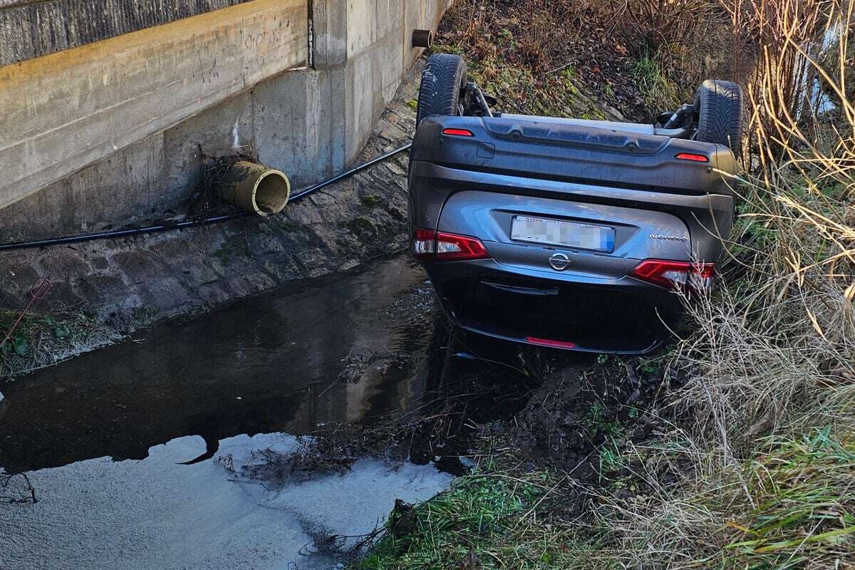 Auto überschlägt sich und landet kopfüber in Bach