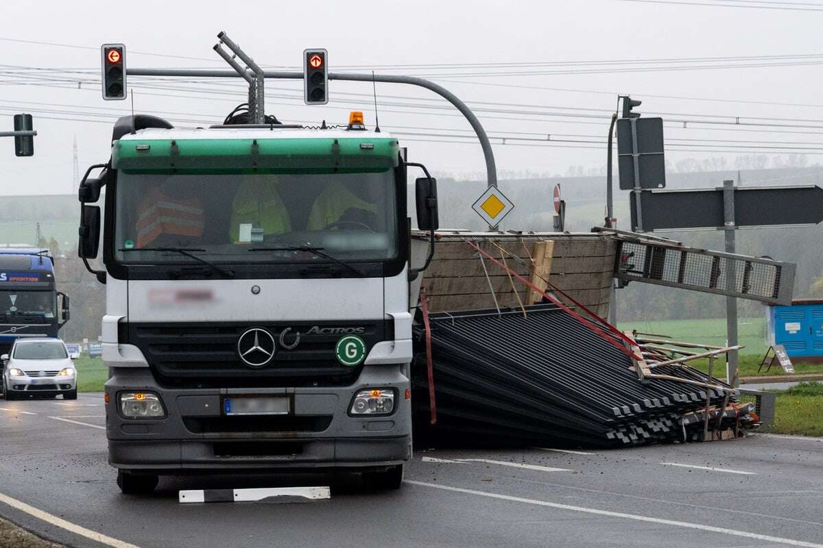 Lkw-Anhänger mit Metallzäunen an Autobahnabfahrt umgestürzt