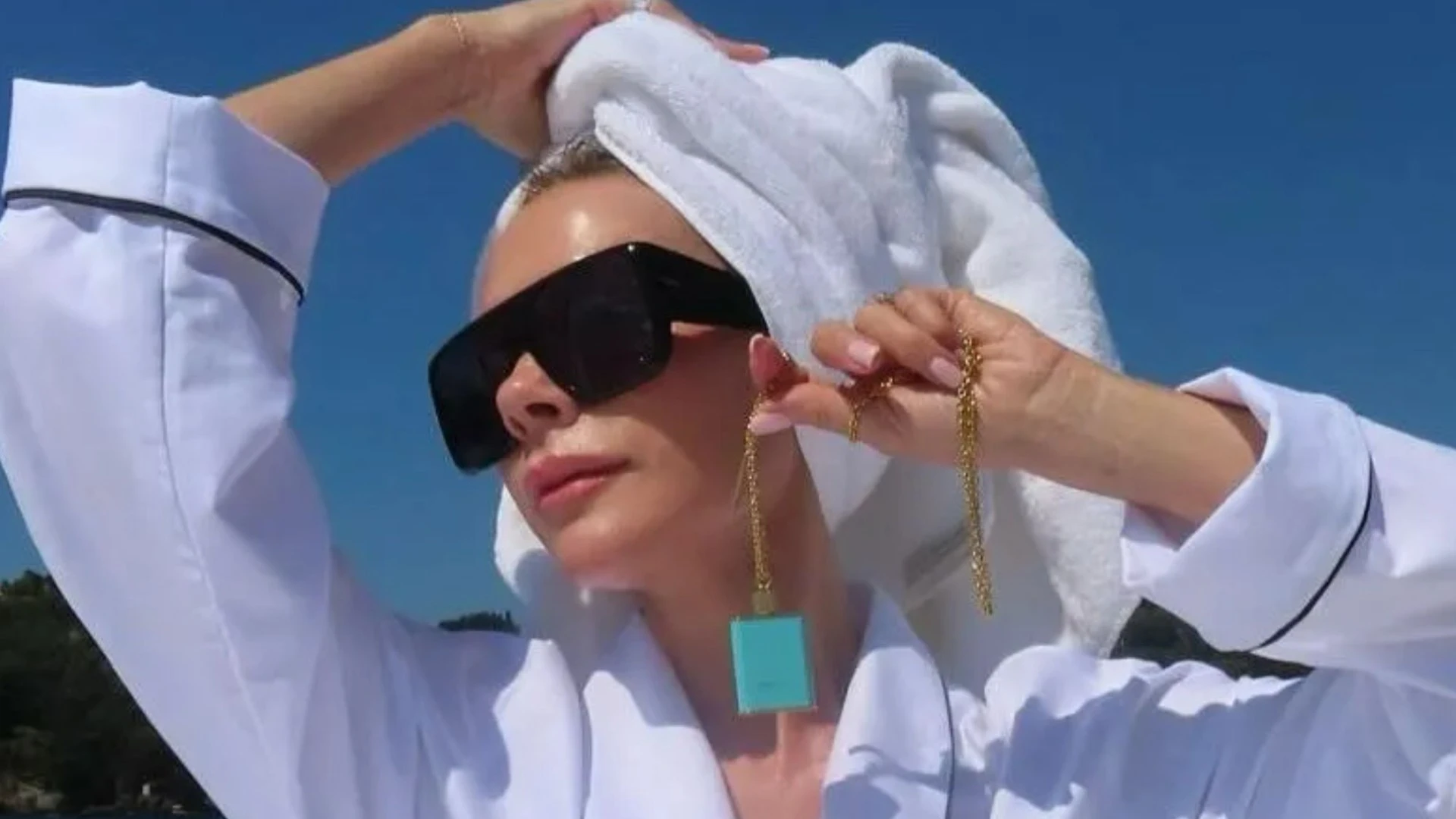 Victoria Beckham shows off tanned legs as she sprawls out in a white robe