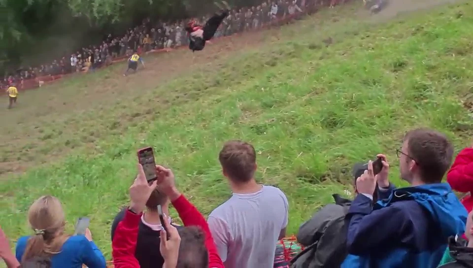 Moment daredevil SOMERSAULTS down hill in pursuit of 7lb wheel of cheese
