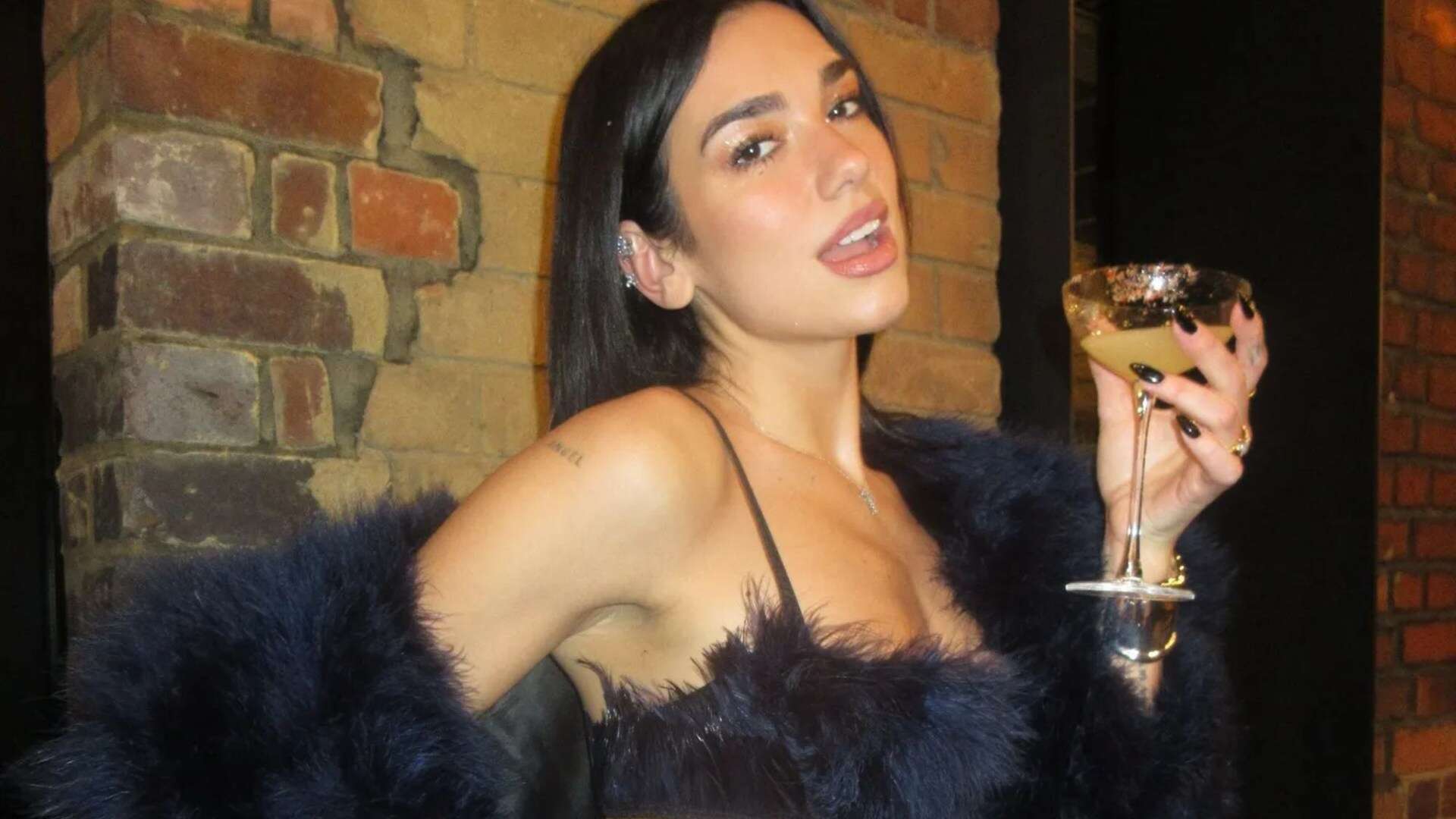 Dua Lipa flashes huge diamond engagement ring as she parties on NYE