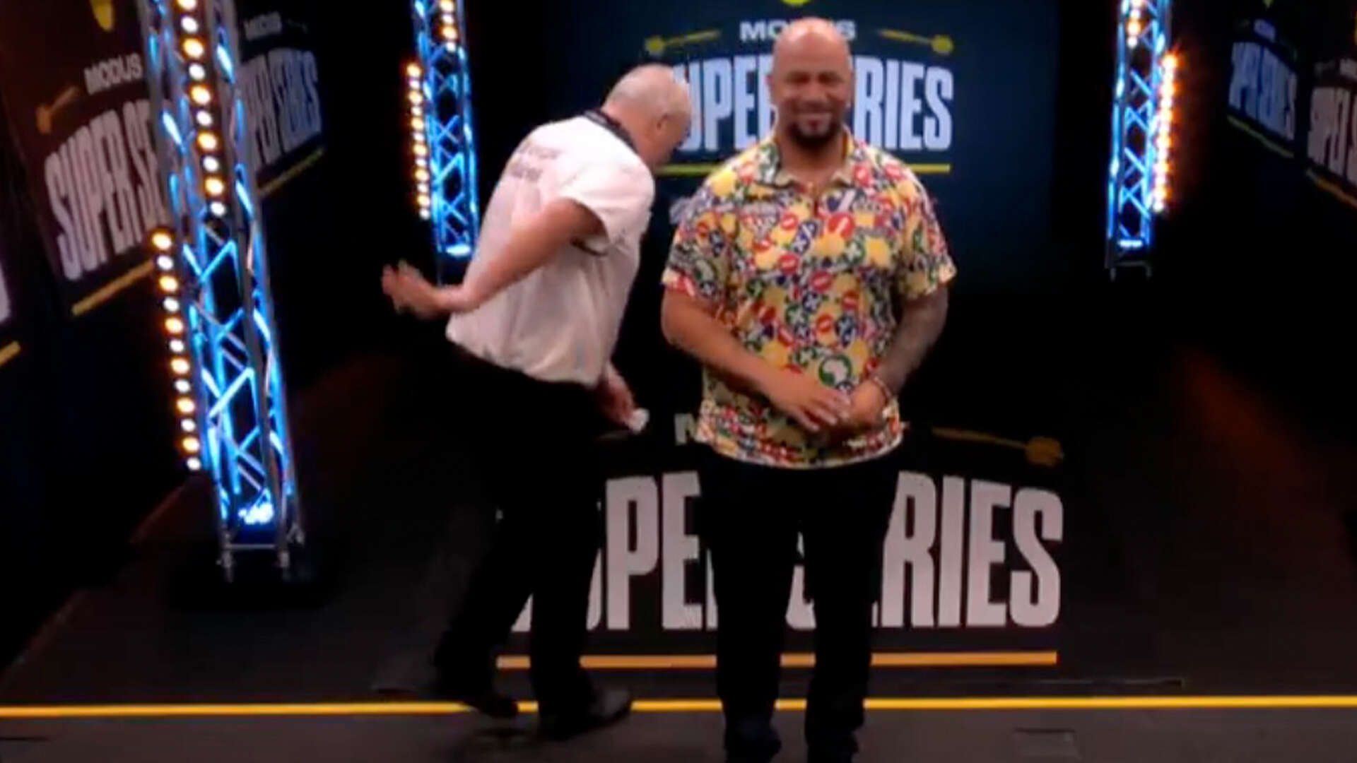 Commentator cracks up as darts icon nearly falls off stage at Super Series