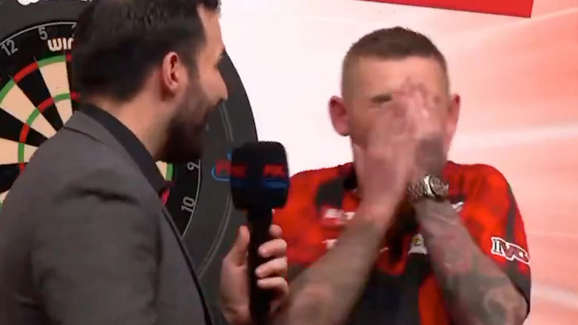 Darts host apologises as Aspinall covers face in horror during interview