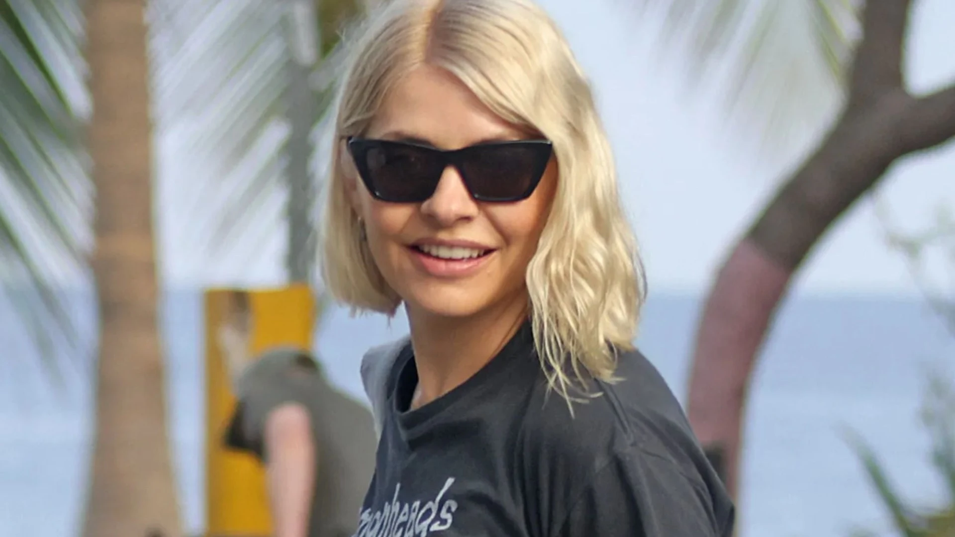 Holly relaxes on beach in war-ravaged Costa Rica as Bear goes paragliding