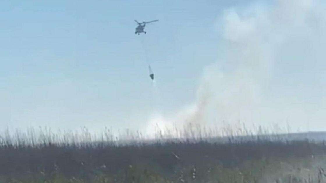 Пожар на берегу Каспийского моря тушат с помощью вертолета: дорог к очагу возгорания нет