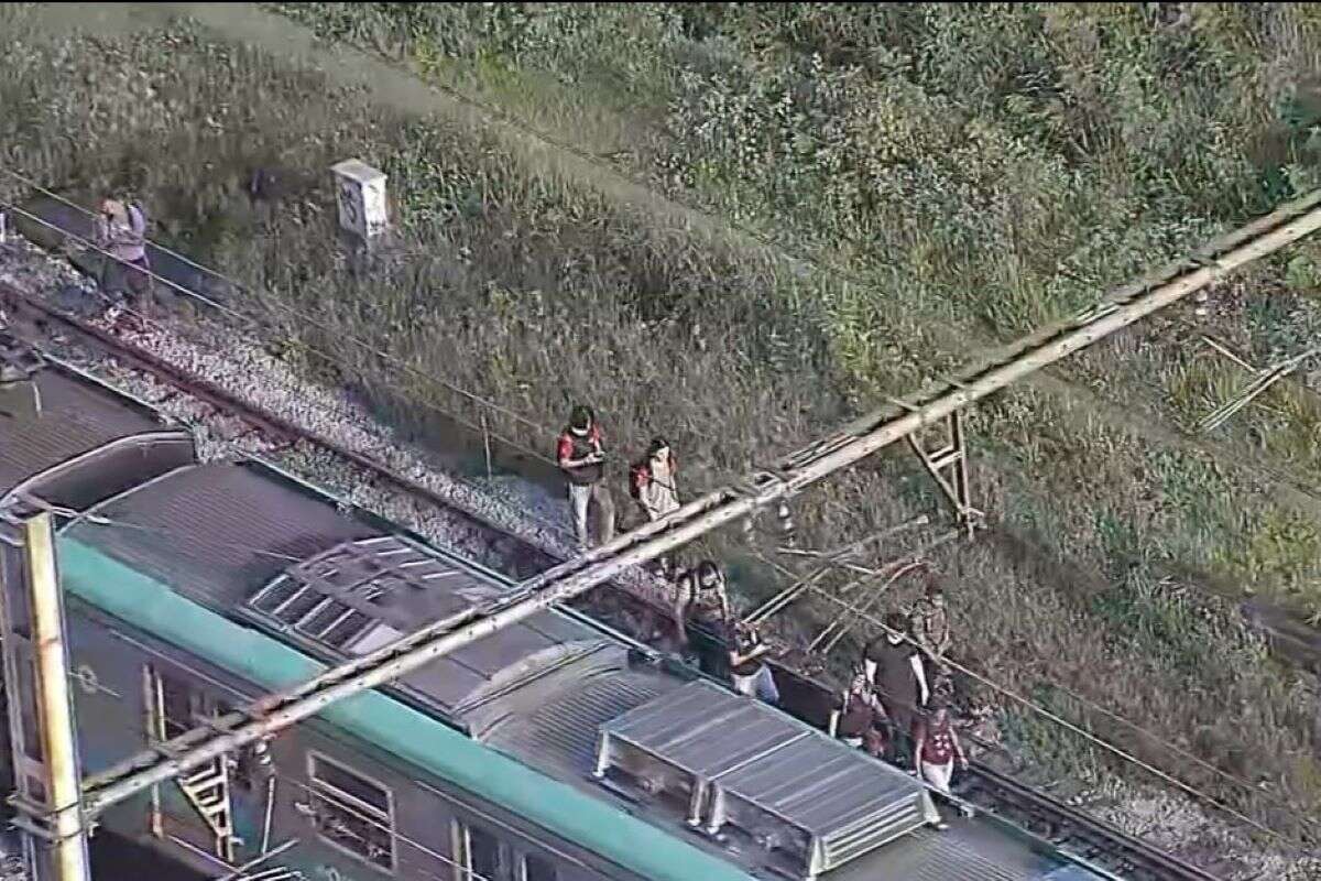 Passageiros caminham sobre trilhos após trem falhar na Linha 8