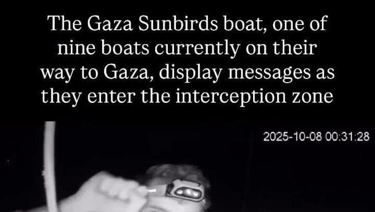 Flotilla, i cartelli per Gaza mostrati da un attivista prima dell'arrivo della marina israeliana