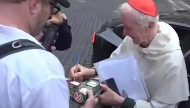 Il cardinale Radcliffe autografa una palla da baseball al collezionista: 