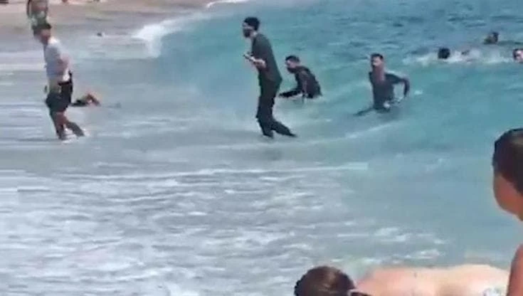 Spagna, migranti sbarcano sulla spiaggia affollata: i bananti fuggono o cercano di catturarli