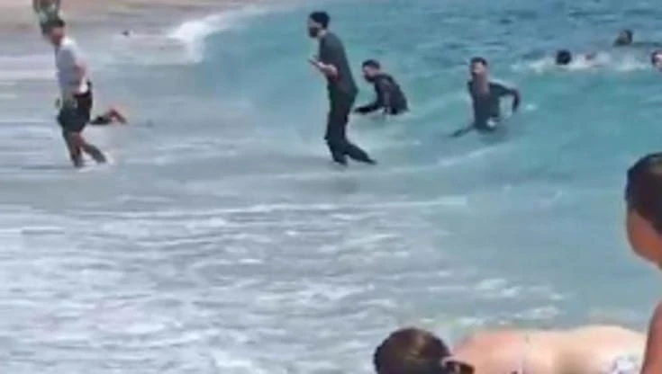 Spagna, migranti sbarcano sulla spiaggia affollata: i bananti fuggono o cercano di catturarli