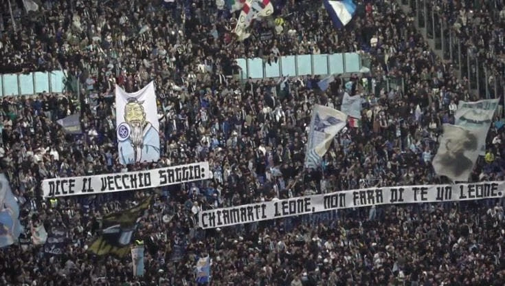 Lazio-Roma - Striscioni e giochi di luce: gli ultras si sfidano sugli spalti a colpi di sfottò