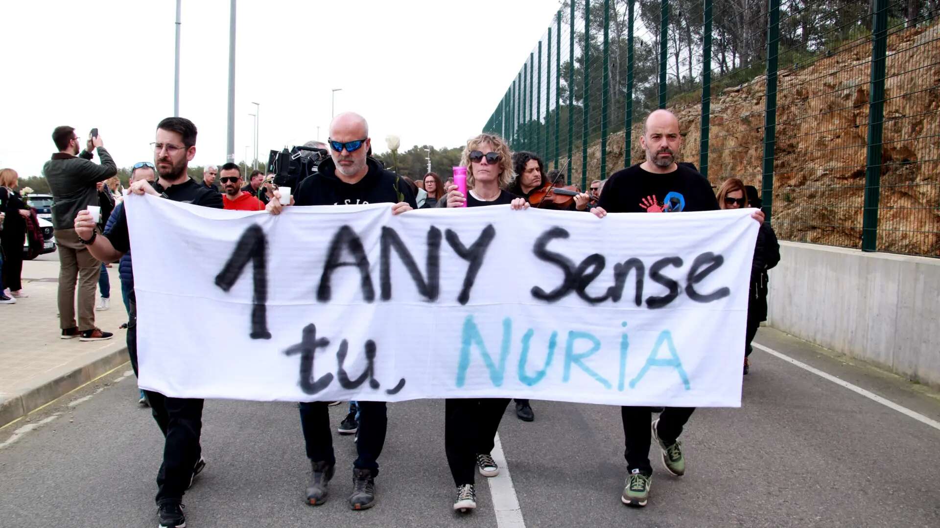 Una marcha lenta, rosas y velas: trabajadores y familiares homenajean a la cocinera asesinada en Mas d'Enric hace un año