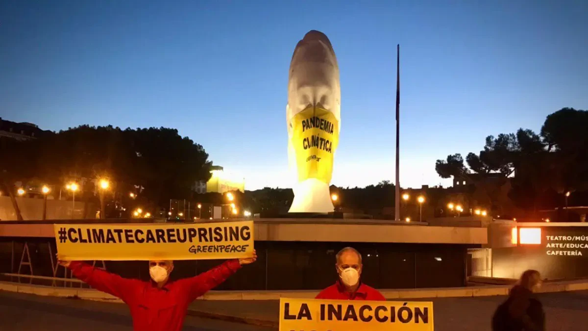 Greenpeace pone una mascarilla gigante a una estatua de la plaza Colón (Madrid) para denunciar la 'pandemia climática'