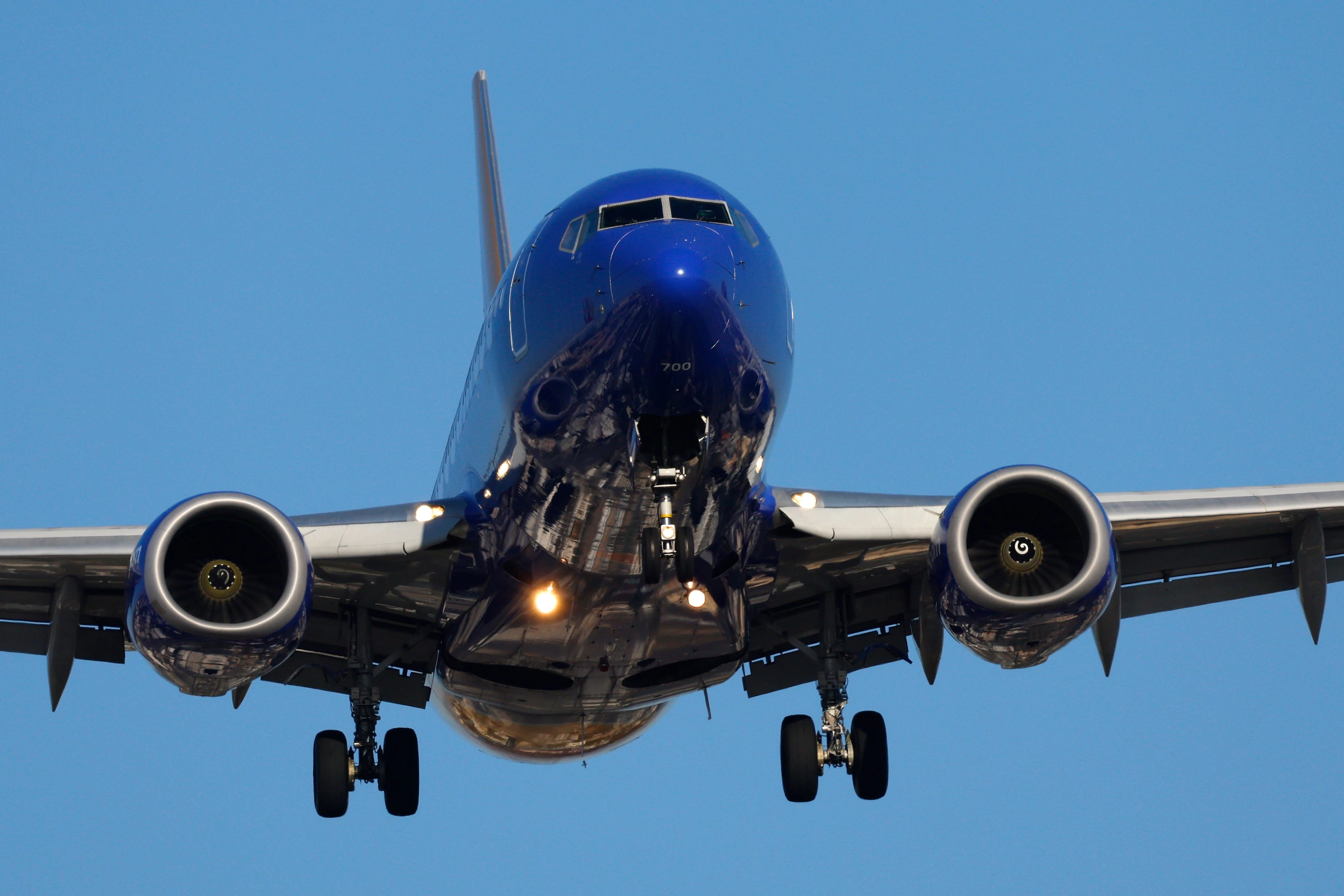 A Southwest passenger kicked and spat at the crew when they tried to stop her from opening an exit in midair, affidavit says