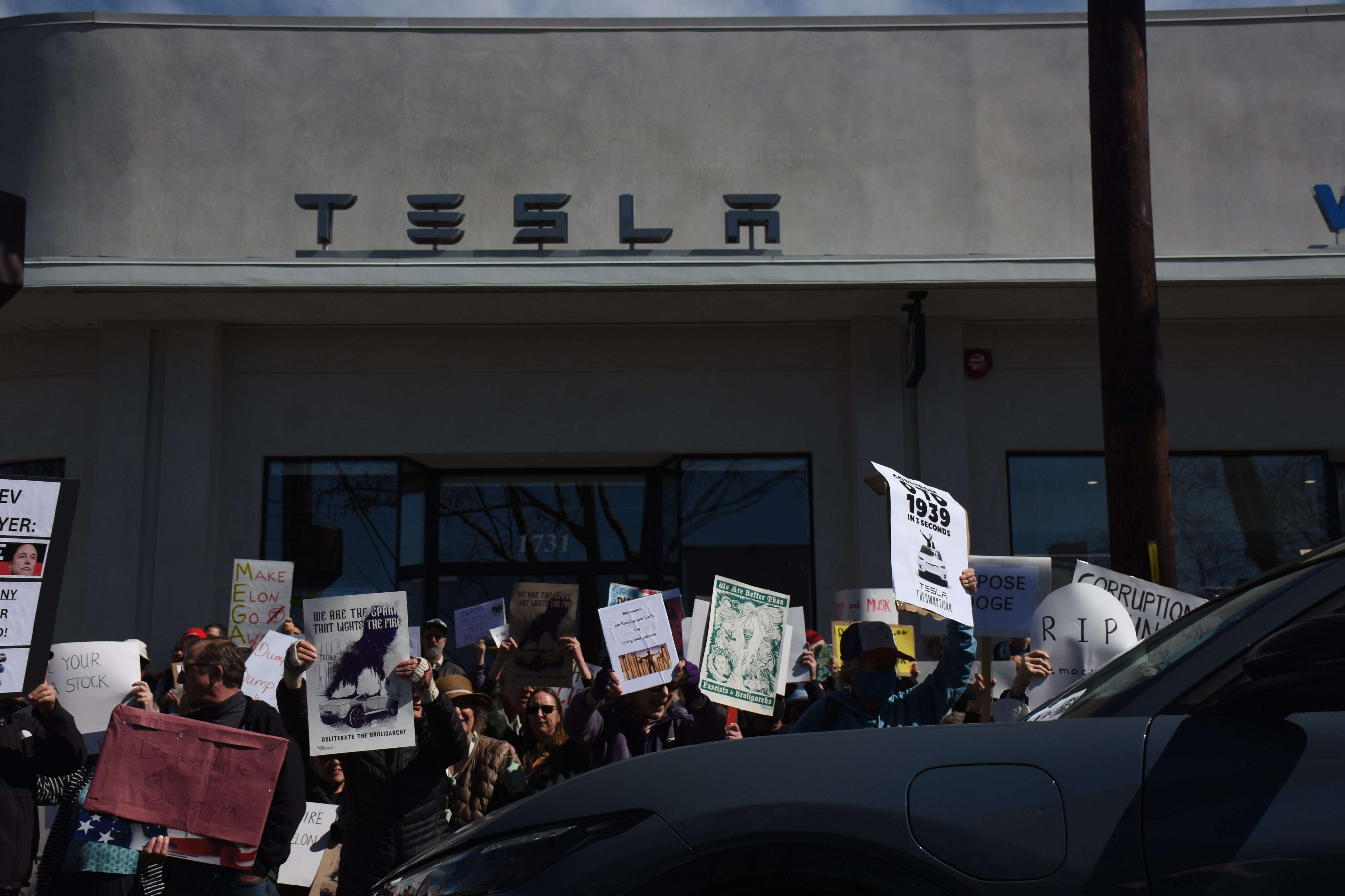 Growing protests target Tesla showrooms with Mariachi bands, raccoon puppets, and cardboard Cybertrucks