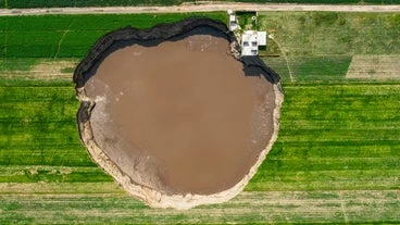 Sinkhole Grows To Size Of Football Field, Threatens House And Traps 2 Dogs