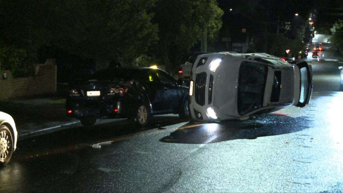 Car flips after crashing into two parked vehicles, sparking manhunt