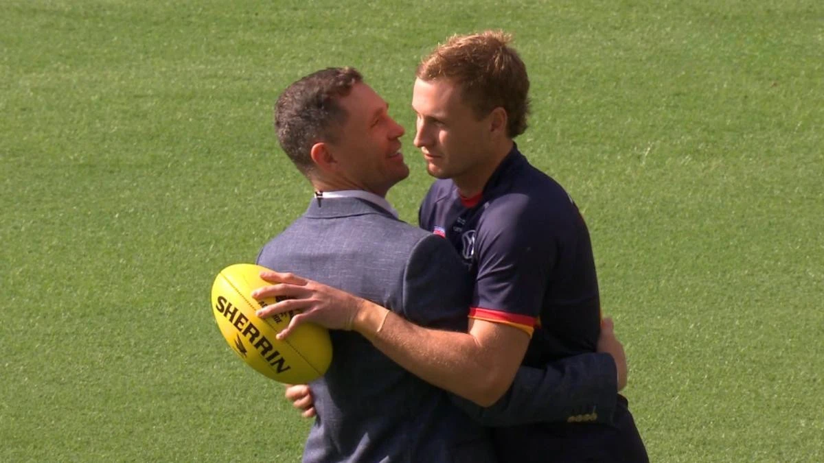 Grieving AFL champions share powerful embrace after family tragedies