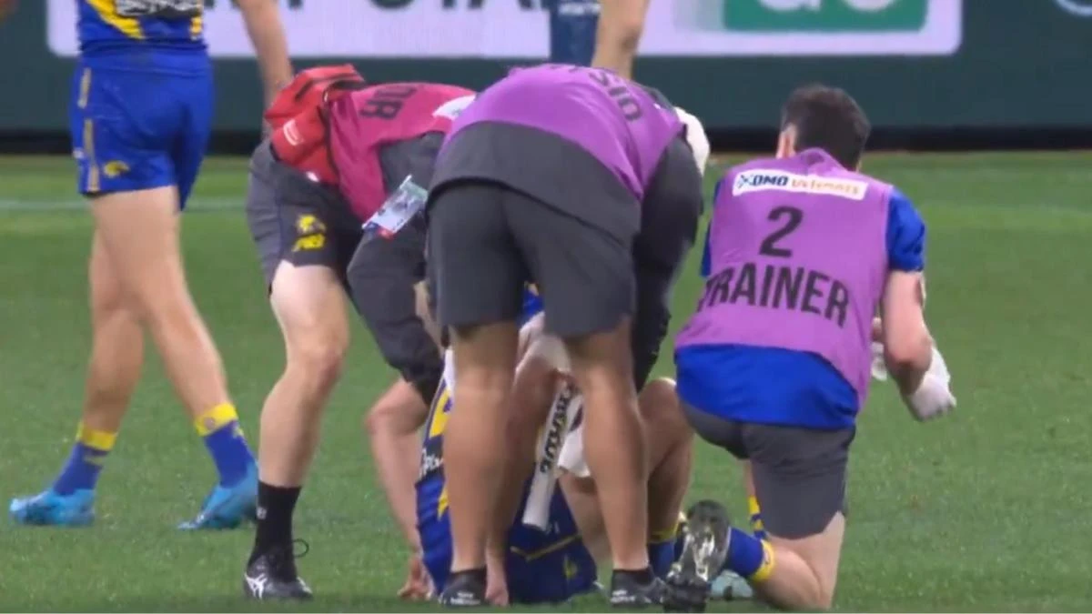 West Coast captain helped from the field in hand of medical staff